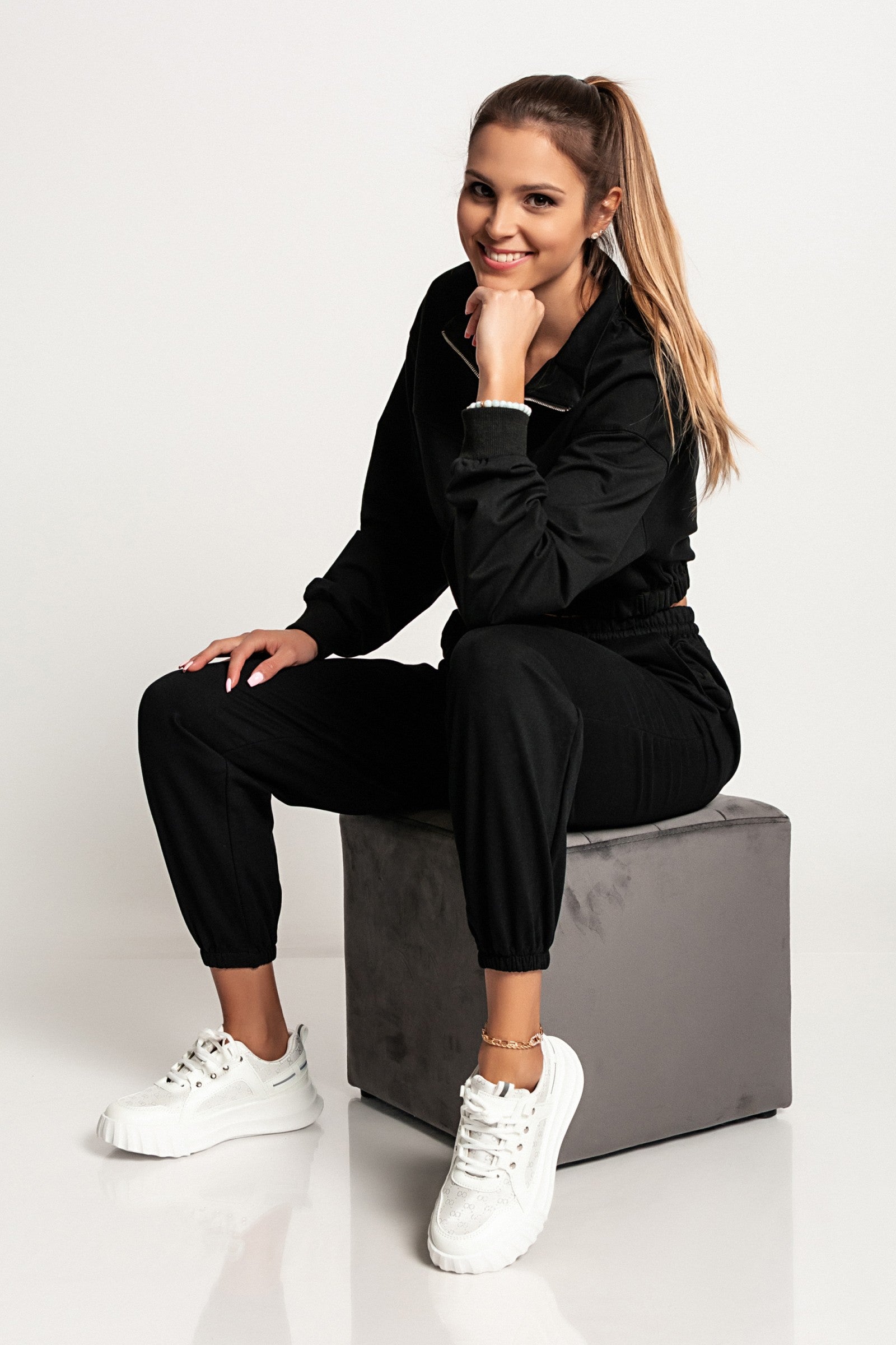 Skrajšana športna majica Polistena v črni barvi z dolgimi rokavi in visokim ovratnikom z zadrgo.